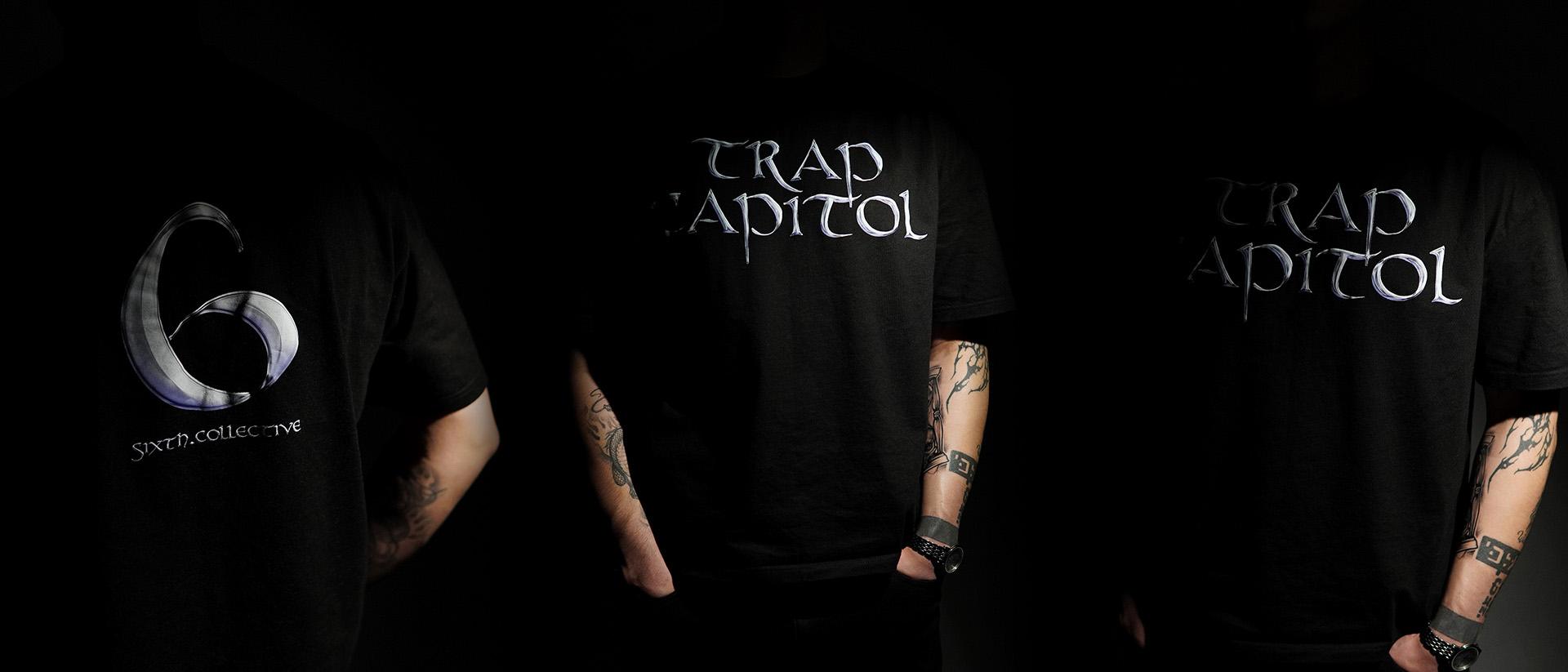 A composite presentation showing three angles of models in a dark setting, highlighting both the front 'TRAP CAPITOL' print and the back '6' graphic on the black t-shirts